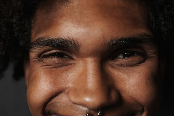 Young black man in t-shirt smiling while showing heart gesture