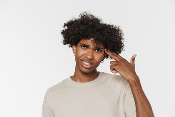 Young black man with piercing frowning while making gun gesture