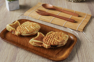 Taiyaki Japanese street food sweet fish-shaped waffle served on a wooden table