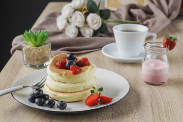 Japanese specialties called souffle pancakes served on a wooden table