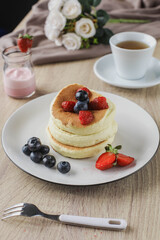 Japanese specialties called souffle pancakes served on a wooden table