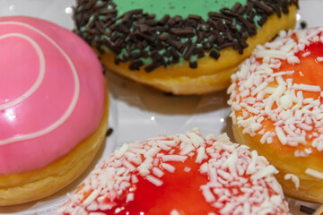 Delicious and tasty of donuts with assorted of colorful topping upside on the paper box