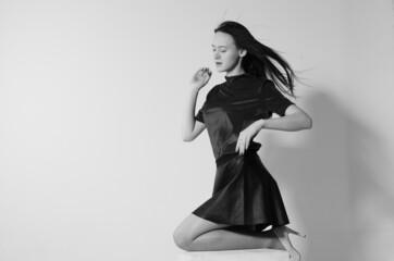 Fashion model with long hair in white shirt and tie on white background.