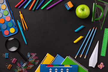 Frame made of school supplies and stationery on a blackboard background, the concept of learning in elementary school and high school, copy space for text