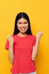 pretty brunette gestures with her hands in casual clothes copy-space yellow background unaltered