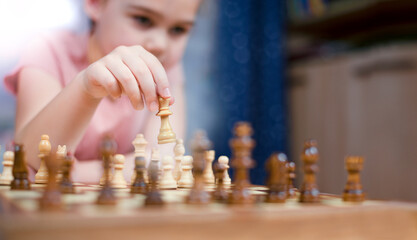 a girl plays chess and makes a king move at home