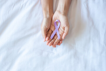 World cancer day (February 4). Woman hand holding Lavender purple ribbon for supporting people...
