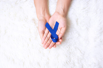 March Colorectal Cancer Awareness month, Man holding dark Blue Ribbon for supporting people living and illness. Healthcare, hope and World cancer day concept