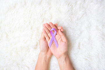 World cancer day (February 4). Woman hand hoy Lavender purple ribbon for supporting people living...