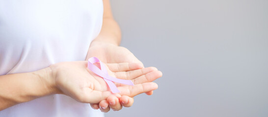 World cancer day (February 4). Woman hand holding Lavender purple ribbon for supporting people living and illness. Healthcare and medical concept