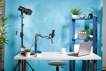 Empty online radio studio broadcasting room with professional microphone and video light used for...