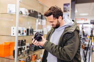 Young man examining camera in store