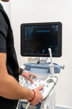Doctor using keyboard on medical equipment in hospital