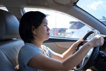 Fototapeta na wymiar Female Asian driver fasten seatbelt and driving a car in highway for travel a vacation trip