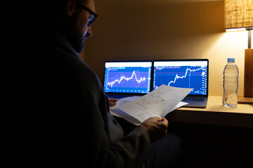 Stock broker analyzing documents trading cryptocurrency working at home office
