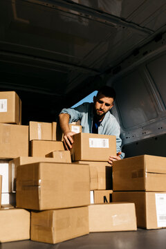 Delivery man picking up package from van
