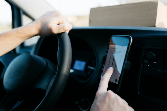Man using GPS on smart phone while driving van