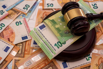 new pure  euro banknotes are laid out and on them a powerful wooden judge's gavel
