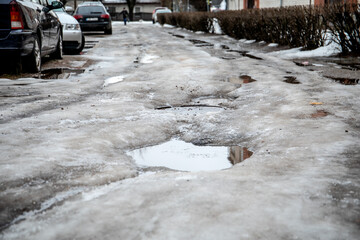 Thaw, wet and bumpy road. Spring and weather changes