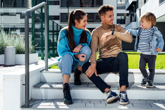 Smiling parents looking at son standing on step
