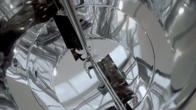 Industrial equipment - chrome-plated mixer with mirror surface and rotating blades for mixing ingredients in food, chemical, pharmaceutical industry. Shot in motion. Closeup