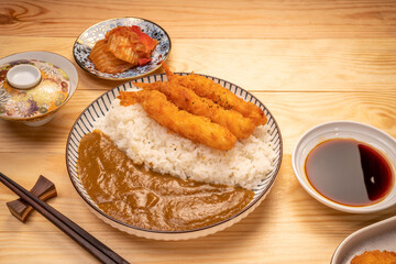 Japanese food curry rice with fried shrimp tempura on wooden table, Traditional Japanese food.