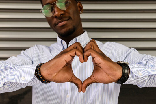 Young man making heart shape with hands