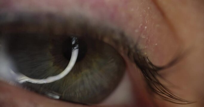 Female eye with gray green pupil slow motion 4k movie