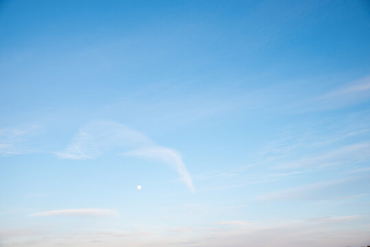 bright blue sky with light haze clouds and moon