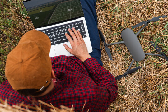 Farmer with laptop and drone on the field. Smart farming and agriculture digitalization
