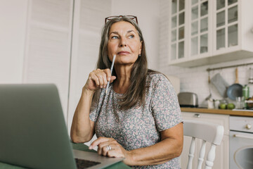 Thoughtful senior woman have bright idea. Deep in her thoughts. Talented journalist or author think about book. Remote work, home office, inspiration, poet, hobby concept - 479509906