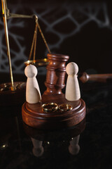 Law and Justice. Vertical image of judge gavel, wooden figures and wedding rings