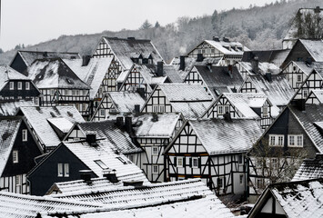 Freudenberg in Sauerland Germany with historic black and white truss half timbered houses in the idyllic old town called “Alter Flecken“. Contrasting Gables, facades and roofs on a cold january day. - obrazy, fototapety, plakaty
