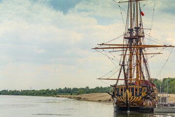 Fototapeta premium Voronezh, Russia, June 11, 2019. People on waterfront look at ship Goto Predistication moored at pier of Admiralty Square. Copy of warship designed by Peter 1.