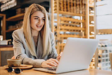 Business woman sitting in cafe and working online