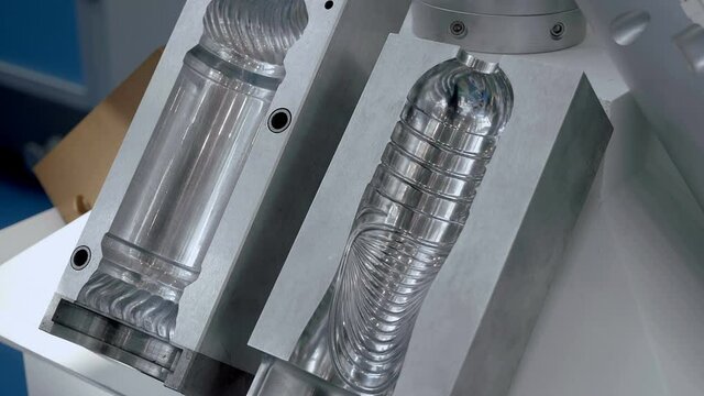 Industrial die for the manufacture of plastic bottles by injection blow moulding (injection stretch blow moulding, ISBM). Shot in motion. Closeup