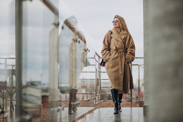 Fototapeta na wymiar Young business woman in coat standing outside