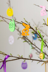 Blooming cherry branches decorated with colorful ribbons with Easter eggs, decorative rabbits, Happy Easter, holiday decoration