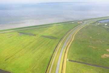 Aerial view of the Lauwersoog coastal landscape. Country road next to the Wadden Sea. near Groningen, Netherlands.