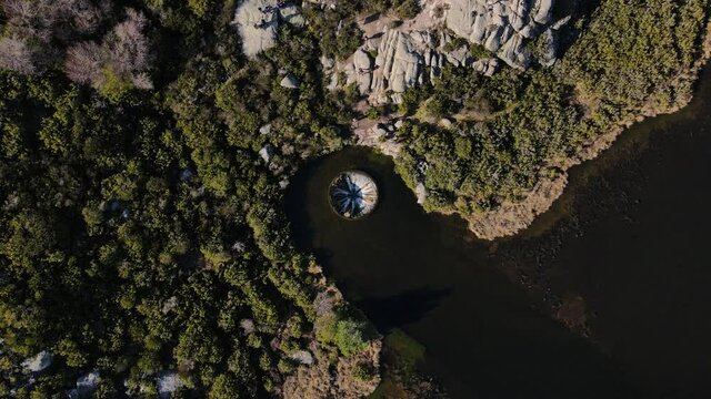 Aerial top down view of a funnel in a lake at Serra da Estrela, Portugal. Cov&atilde;o dos Conchos water hole on a sunny bright day. Wild nature surrounding.