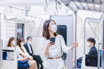 マスクをして電車にのる女性