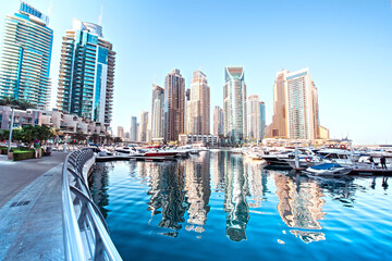 Obraz premium Dubai, United Arab Emirates – February 13, 2021: Scenic view of a yachts at Dubai Marina in the largest city in the United Arab Emirates against the backdrop of skyscrapers.