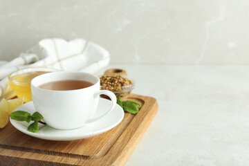 Concept of hot drink with buckwheat tea on light textured table