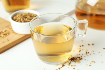 Concept of hot drink with buckwheat tea on white background
