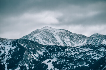 Fototapeta na wymiar montaña nevada con un cielo nubloso en Pirineo Andorra 