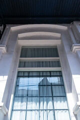 Obraz premium Low angle of vintage and old white wood square window from the heritage building architecture