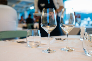 Table settings for fine dining with and glassware, beautiful blurred background. Diner at the shore of the Mediterranean Sea. Food concept.