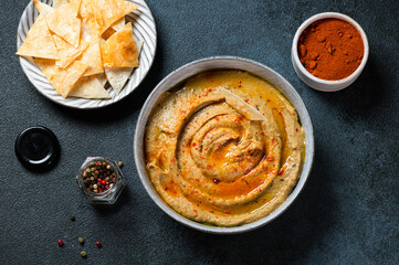 Traditional arabian eggplant dip baba ganoush with herbs and smoked paprika on dark background. Eggplant hummus. Babaganush or eggplant caviar. Baked eggplant. Turkish eggplant dip