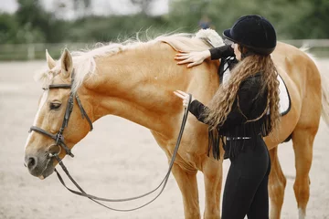 Foto op Canvas Portrait of riding horse with woman in black helmet © hetmanstock2