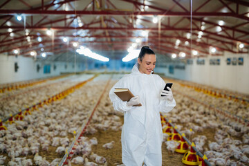 woman veterinarian using mobile phone on chicken farm © cherryandbees